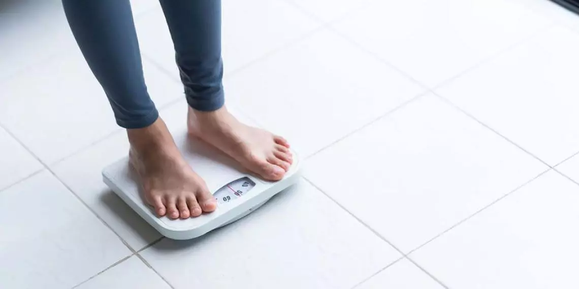Person-on-scale-illustrating-the-link-between-blood-sugar-instability-and-weight-management-challenges.jpg