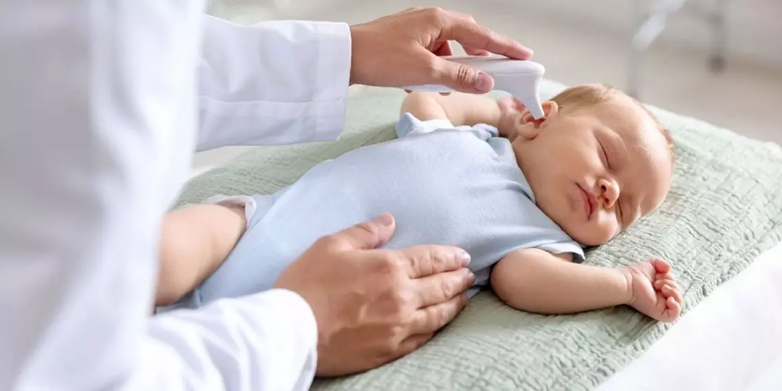 Doctor examines baby’s ear for signs of infection