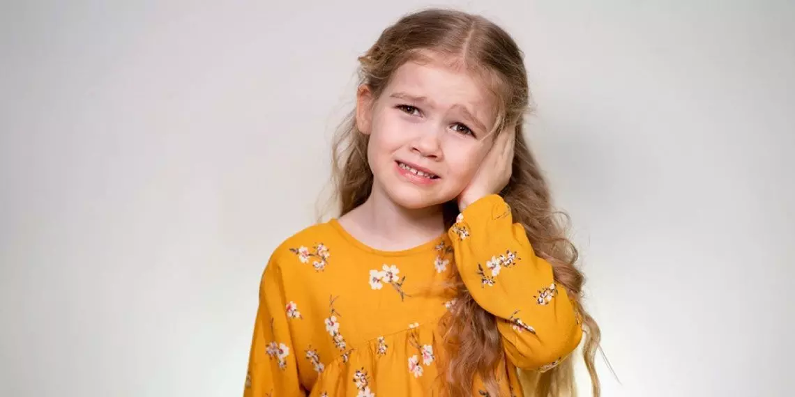 Girl experiencing earache symptoms from possible ear infection