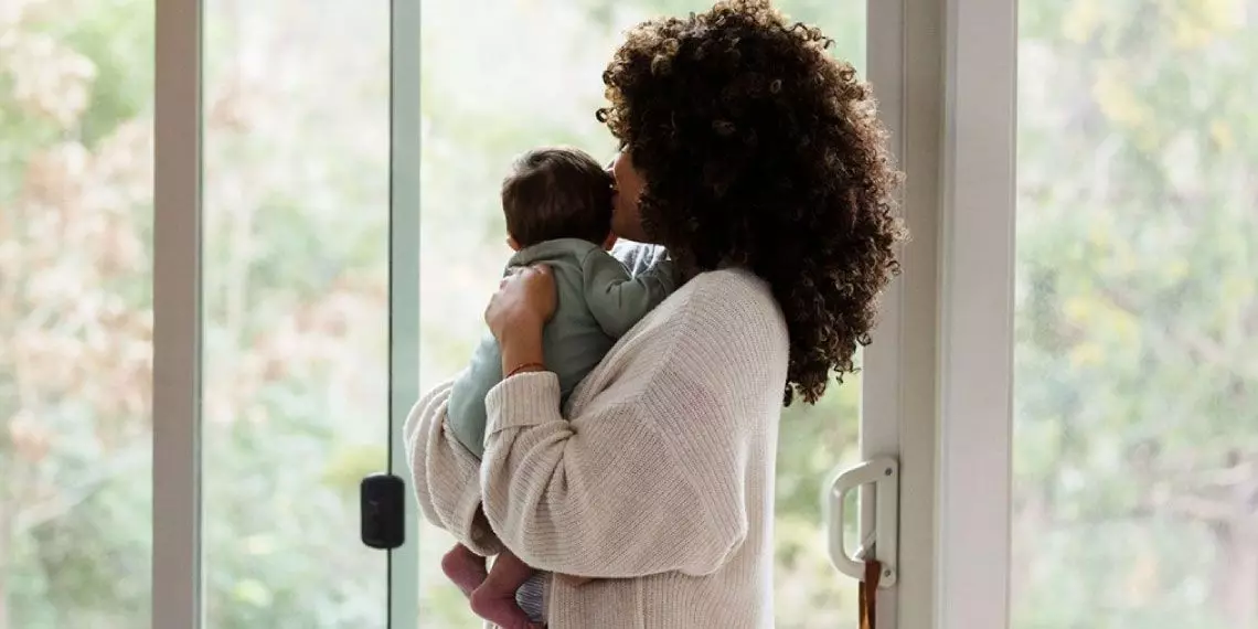 Mother holding baby near window