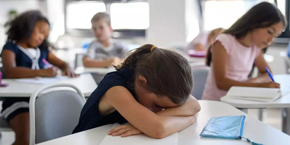Withdrawn child at school showing signs of anxiety beyond normal back to school nerves