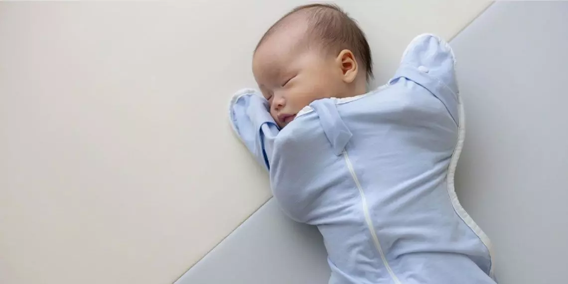 Swaddled newborn sleeping safely