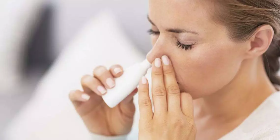 Woman-using-nasal-spray-to-treat-sinus-pressure-and-congestion.jpg